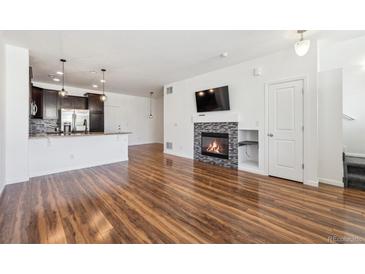 Spacious living room featuring hardwood floors and a cozy fireplace at 16285 W 62Nd Ln # C, Arvada, CO 80403