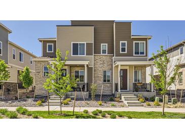 Modern townhome featuring a brick facade, landscaped front yard, and inviting front porch at 24374 E 42Nd Ave, Aurora, CO 80019