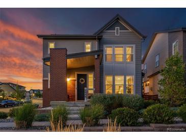 Charming two-story home features a brick accent wall, covered porch, and professionally landscaped front yard at 8846 Yates Dr, Westminster, CO 80031