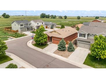 Beautiful street view of craftsman style homes with well-manicured lawns and lush landscaping at 1836 Taos St, Brighton, CO 80603
