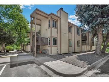 Two-story condo building featuring wood siding, a private entrance, and mature landscaping at 1111 S Garrison St # 202, Lakewood, CO 80232