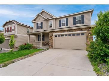 Charming two-story home featuring a stone facade, attached two car garage, and manicured front yard at 4666 S Malaya Ct, Aurora, CO 80015