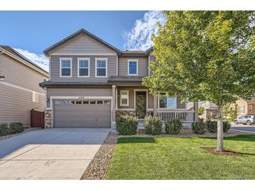 Charming two-story home with a manicured lawn, inviting front porch, and a two car garage at 12510 Fisher St, Englewood, CO 80112