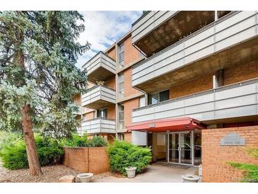 Brick condo building featuring multiple balconies and well-maintained landscaping at 2500 S York St # 401, Denver, CO 80210