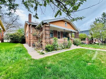 Charming brick home with a well-manicured lawn and inviting front porch at 767 S York St, Denver, CO 80209