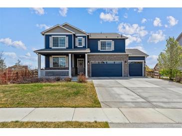 Charming two-story home featuring a welcoming front porch and a three-car attached garage at 7498 E 157Th Pl, Thornton, CO 80602