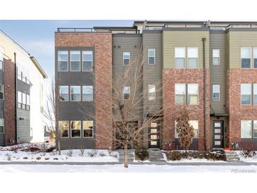 Modern three-story townhome with brick and siding exterior at 8932 E 47Th Ave, Denver, CO 80238