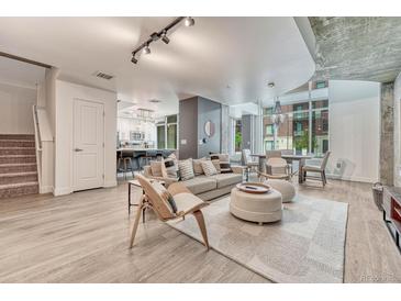 Bright living room boasts an open floor plan, with adjacent kitchen and dining areas, and modern decor at 1700 Bassett St # 101, Denver, CO 80202