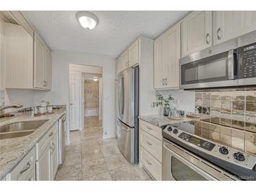 Well-lit kitchen featuring stainless steel appliances and contrasting countertops at 4800 E Hale Pkwy # 802N, Denver, CO 80220