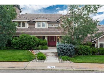 Charming two-story home with manicured lawn and mature trees, creating inviting curb appeal at 7750 S Glencoe Way, Centennial, CO 80122