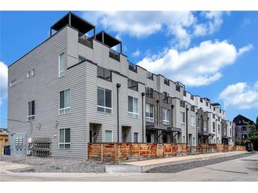 Contemporary townhomes featuring rooftop decks and modern exteriors, with grey siding, black trim, and wood privacy fences at 3520 W Conejos Pl # 14, Denver, CO 80204