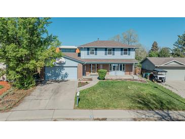 Charming two-story home featuring blue siding, brick accents, and a well-manicured front lawn at 6621 S Cherry Way, Centennial, CO 80121