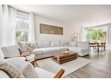 Bright, open living room with neutral tones, modern decor, and large sectional sofa at 14833 E Crestridge Dr, Centennial, CO 80015