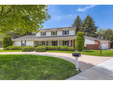 Charming two-story home with lush landscaping, circular driveway, and well-maintained lawn at 10130 E Powers Ave, Greenwood Village, CO 80111