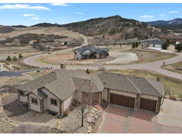 Expansive aerial view of the estate home with a three car garage, circular driveway, and mountain views at 5265 Club Ct, Larkspur, CO 80118
