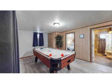 Basement game room with air hockey table and bathroom at 1242 Elder St, Denver, CO 80221
