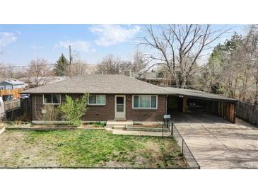 Brick ranch home with carport and fenced yard at 1242 Elder St, Denver, CO 80221