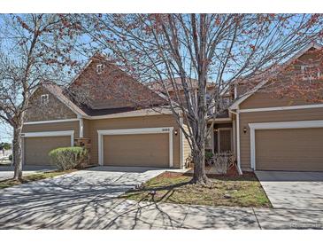 Inviting townhome featuring a two-car garage and well-maintained landscaping at 6004 W Colorado Ln, Lakewood, CO 80232