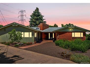 Charming single-story home featuring a brick facade, mature trees, and well-maintained landscaping at 10400 W 35Th Pl, Wheat Ridge, CO 80033