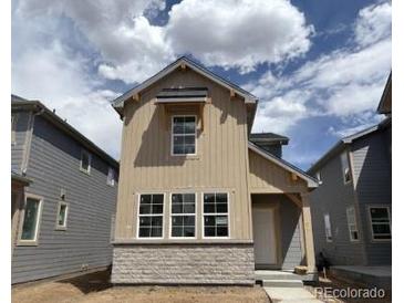 Charming two-story home featuring beige siding, stone accents, and well-placed windows at 2079 Generations Aly, Brighton, CO 80601