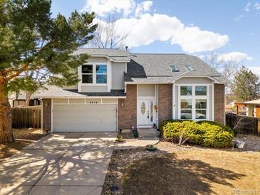 Charming two-story home with a well-manicured lawn, brick accents, and an attached two-car garage at 3819 S Waco St, Aurora, CO 80013