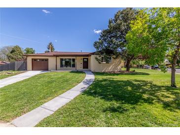 Charming one-story home with a well-manicured lawn, a concrete walkway, and a brown garage door at 190 Hemlock St, Broomfield, CO 80020