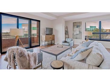 Bright living room with comfortable seating and access to a balcony at 4875 S Monaco St # 408, Denver, CO 80237