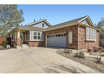 Inviting brick home featuring a spacious driveway and a two-car garage, set under a clear blue sky at 20040 E Doane Dr, Aurora, CO 80013