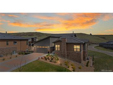 Beautiful home exterior with a well-manicured lawn and mountain views at sunset at 10869 Bluffside Dr, Lone Tree, CO 80124