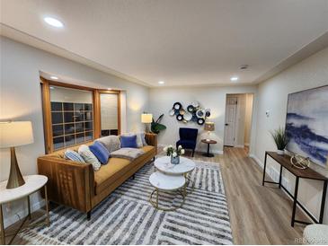 Bright living room with stylish furniture and hardwood floors at 8318 Benton Way, Arvada, CO 80003