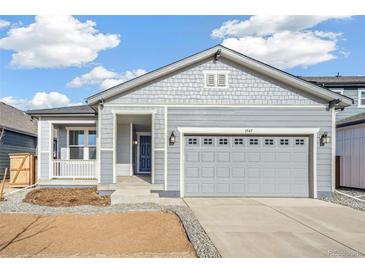 Gray exterior of charming ranch home with attached garage and front porch at 1547 Orchard St, Brighton, CO 80601