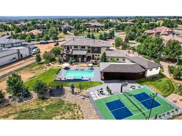 Expansive backyard featuring a pool, sport court, trampoline, and outdoor seating area at 2635 Spruce Meadows Dr, Broomfield, CO 80023