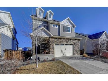 Charming two-story home with a stone-accented facade and a well-maintained front yard in a suburban neighborhood at 26293 E Archer Ave, Aurora, CO 80018