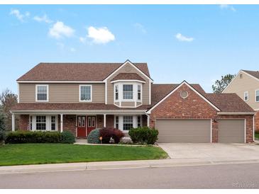 Charming two-story home with a well-manicured lawn, brick accents, and a three-car garage at 5454 S Everett Ct, Littleton, CO 80123