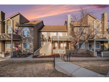 Inviting multi-level townhome with a manicured lawn and cozy front patio, perfect for relaxing outdoors at 1079 S Walden Way # 217, Aurora, CO 80017