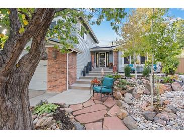 Charming home featuring a landscaped front yard, brick accents, and a cozy seating area at 87 Prairie Ridge Rd, Highlands Ranch, CO 80126