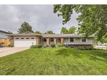 Charming ranch style home with a brick front, well-manicured lawn, and an attached two car garage at 7746 S Gray St, Littleton, CO 80128