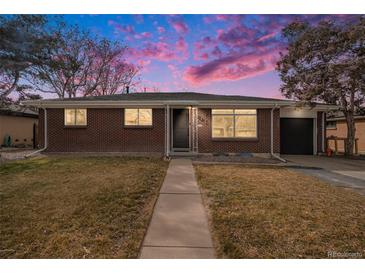 Charming brick home with a well-maintained lawn and a welcoming walkway to the front door at 3149 Wheeling St, Aurora, CO 80011