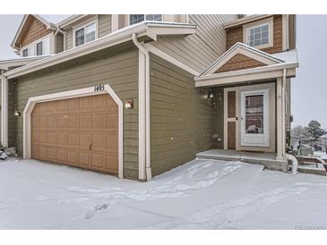 Exterior view of a two-story townhome with snow on the ground and an attached garage at 1405 Willow Oak Rd, Castle Rock, CO 80104