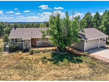 Ranch style home featuring mature landscaping, deck, and attached garage at 1817 Buttercup Rd, Elizabeth, CO 80107