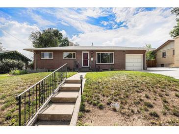 Charming single-story brick home featuring an attached garage and a well-manicured front yard with stairs at 2939 S Zurich Ct, Denver, CO 80236