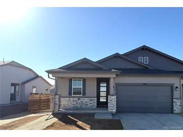 Charming single Gathering home featuring stone accents, a covered porch, and an attached two car garage at 3441 N Denali St, Aurora, CO 80019