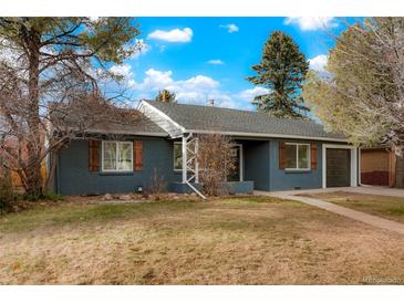 Charming single story home with a well-maintained yard, painted brick, shutters, and a cozy, inviting facade at 211 Newport St, Denver, CO 80220