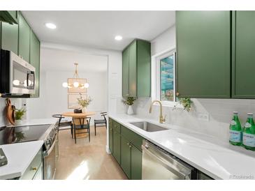 Bright kitchen featuring green cabinets, white countertops, stainless steel appliances and a view into the dining area at 211 Newport St, Denver, CO 80220