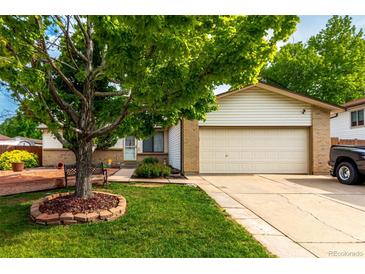 Charming home with a well-manicured lawn, mature shade tree, and a welcoming two-car garage at 4520 E 112Th Pl, Thornton, CO 80233
