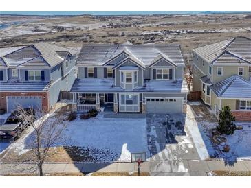 Charming two-story home with a well-manicured front yard dusted with snow at 15972 E Tall Timber Ln, Parker, CO 80134