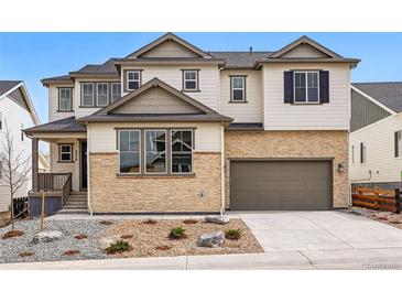 Charming two-story home featuring a stone facade, attached garage, and manicured front yard at 3370 Backdrop Ct, Castle Rock, CO 80108