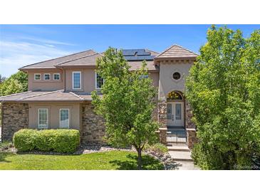 Elegant two-story home featuring a stone facade, tile roof, and lush landscaping at 14325 N Santa Fe St, Broomfield, CO 80023