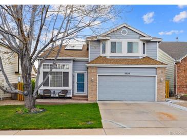 Charming two-story home with a well-manicured lawn, a brick-accented garage, and a cozy front porch at 2529 S Truckee Way, Aurora, CO 80013