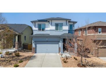 Charming two-story home featuring a gray garage door, stone accents and well-kept landscaping at 3111 Youngheart Way, Castle Rock, CO 80109